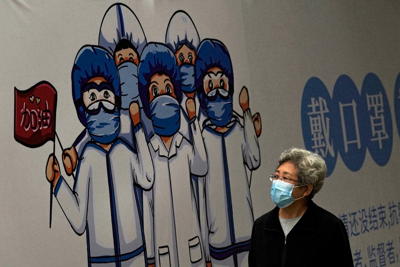 Một pano trên đường phố Bắc Kinh với hình vẽ nhân viên y tế cổ vũ "Hãy mang khẩu trang" để chống Covid-19, 14/10/2021. Ảnh: AP/Andy Wong