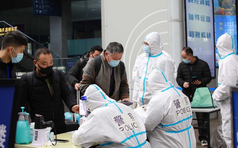 Cảnh sát mặc đồ bảo hộ kiểm tra thông tin sức khỏe của hành khách tại ga Nam Kinh, tỉnh Giang Tô, Trung Quốc hôm 17/1. Ảnh: Reuters