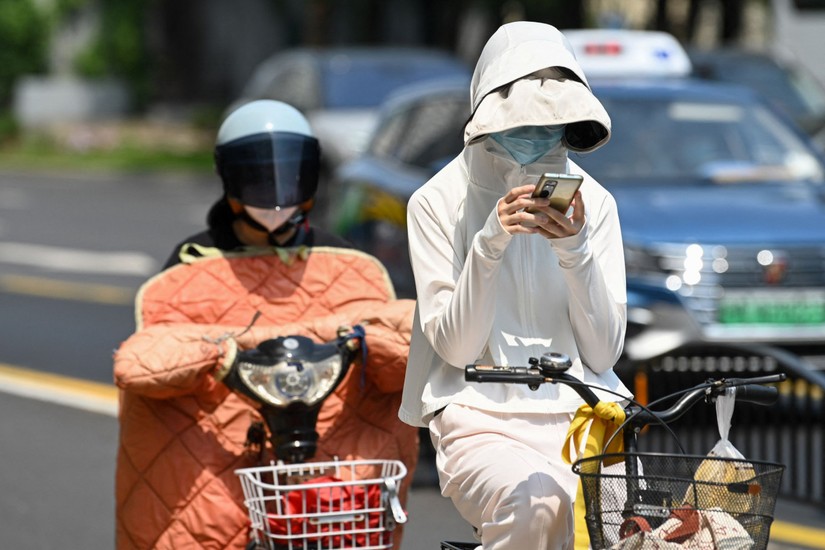 Người dân Trung Quốc mặc quần áo chống nắng dưới thời tiết nắng nóng ở Thượng Hải, ngày 29/5. Ảnh: AFP