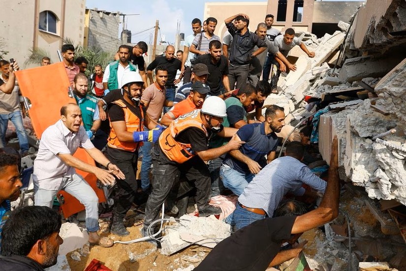 Người dân Palestine tìm kiếm người thương vong dưới đống đổ nát của một ngôi nhà bị phá hủy trong cuộc tấn công của Israel ở Khan Younis, phía nam Dải Gaza, ngày 8/10. Ảnh: Reuters
