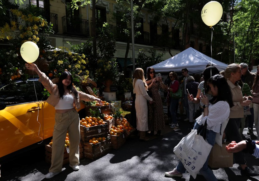 Du khách Trung Quốc chụp ảnh tại phiên chợ ngoài trời ở thành phố Salamanca, Madrid, Tây Ban Nha. Ảnh: Reuters